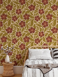 Vintage Flowers Dance wallpaper, rust blooms and leaves behind a rattan bed with striped pillows in a bedroom
