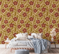 Vintage Flowers Dance wallpaper, rust flowers on tan behind a wood platform bed with a blue throw in a bedroom