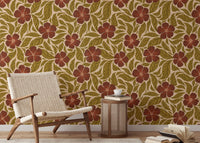 Vintage Flowers Dance wallpaper, rust blooms and green leaves behind a woven wood chair in a living room