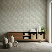Vintage Folk Tiles Sage Green wallpaper above a low wood sideboard with vases and baskets in a minimalist room
