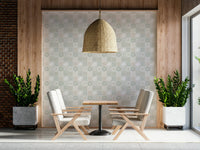 Vintage Folk Tiles Sage Green wallpaper on a wood-panel wall behind two cream armchairs under a rattan pendant