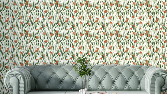 Wandering Blooms wallpaper with terracotta buds on green leaves behind a sage velvet tufted sofa in a living room