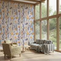 Warm Meadow Harmony wallpaper of orange and blue meadow flowers in a sunroom with a striped sofa by the garden