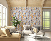Warm Meadow Harmony wallpaper of amber and grey wildflowers behind grey and yellow sofas in a wood-beam lounge