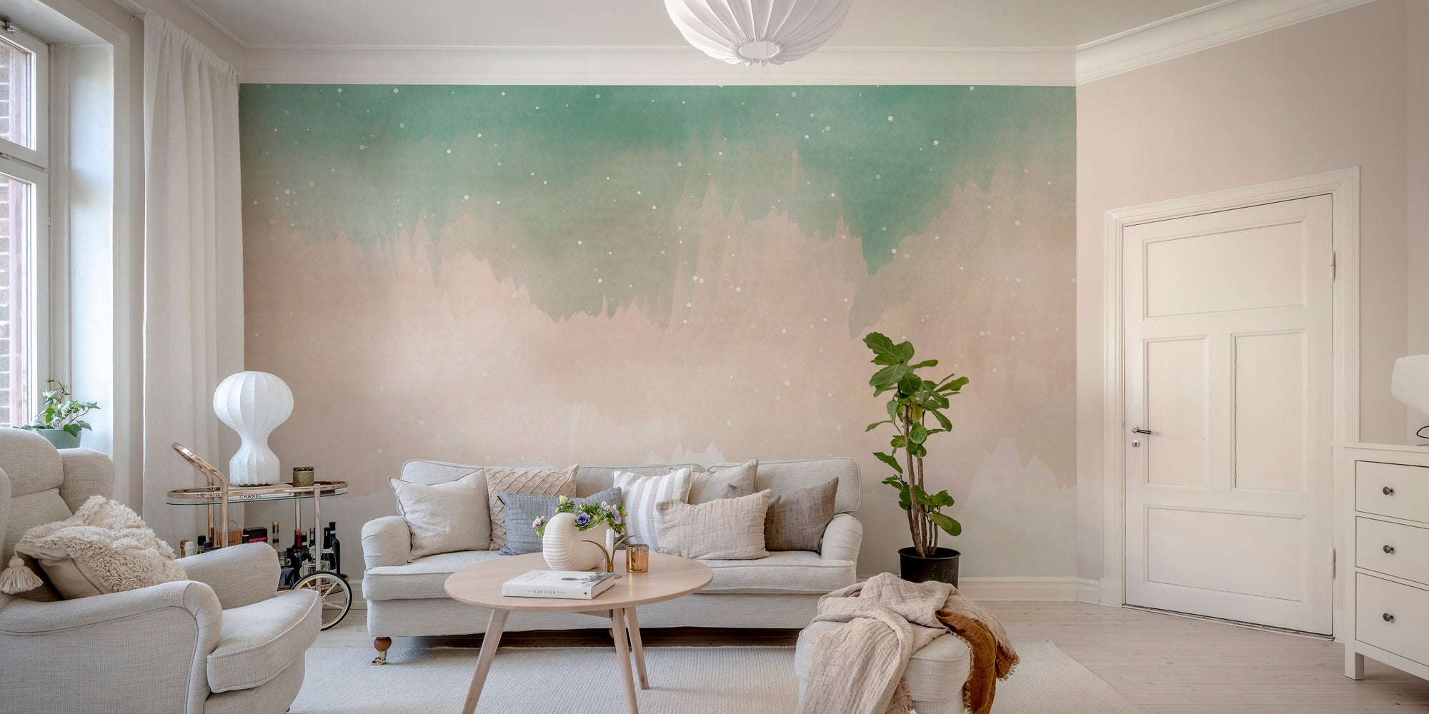 Colorful Watercolor Ombre wallpaper mural in green and blush behind a gray sofa in a bright living room