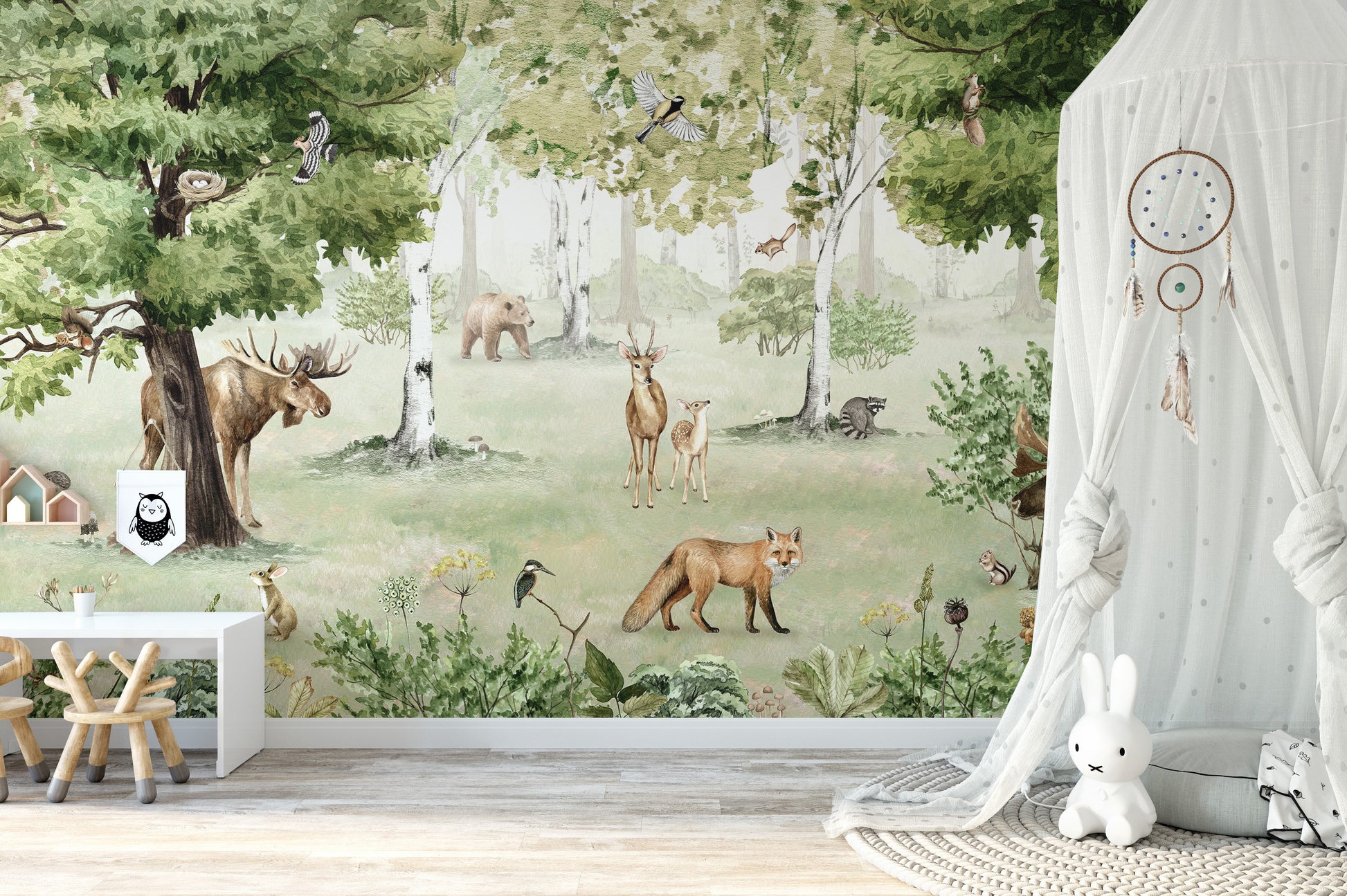 Watercolor Woodland Wonders wallpaper mural with a fox and deer beside a white canopy drape and plush bunny in a nursery