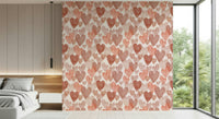 Soft pastel wallpaper mural filled with overlapping watercolor hearts in warm blush hues.
