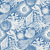 Organic white fish and shell forms spread across the denim blue boho wallpaper