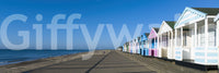 Deep ocean blue meets pale sand along the Colorful Beach Hut wall mural