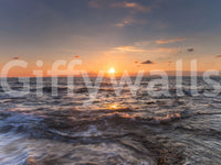 Sundown glow over moving water runs the length of this ocean wall mural