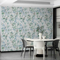 Sage green botanical print in a contemporary bathroom with brass taps and mirrors.