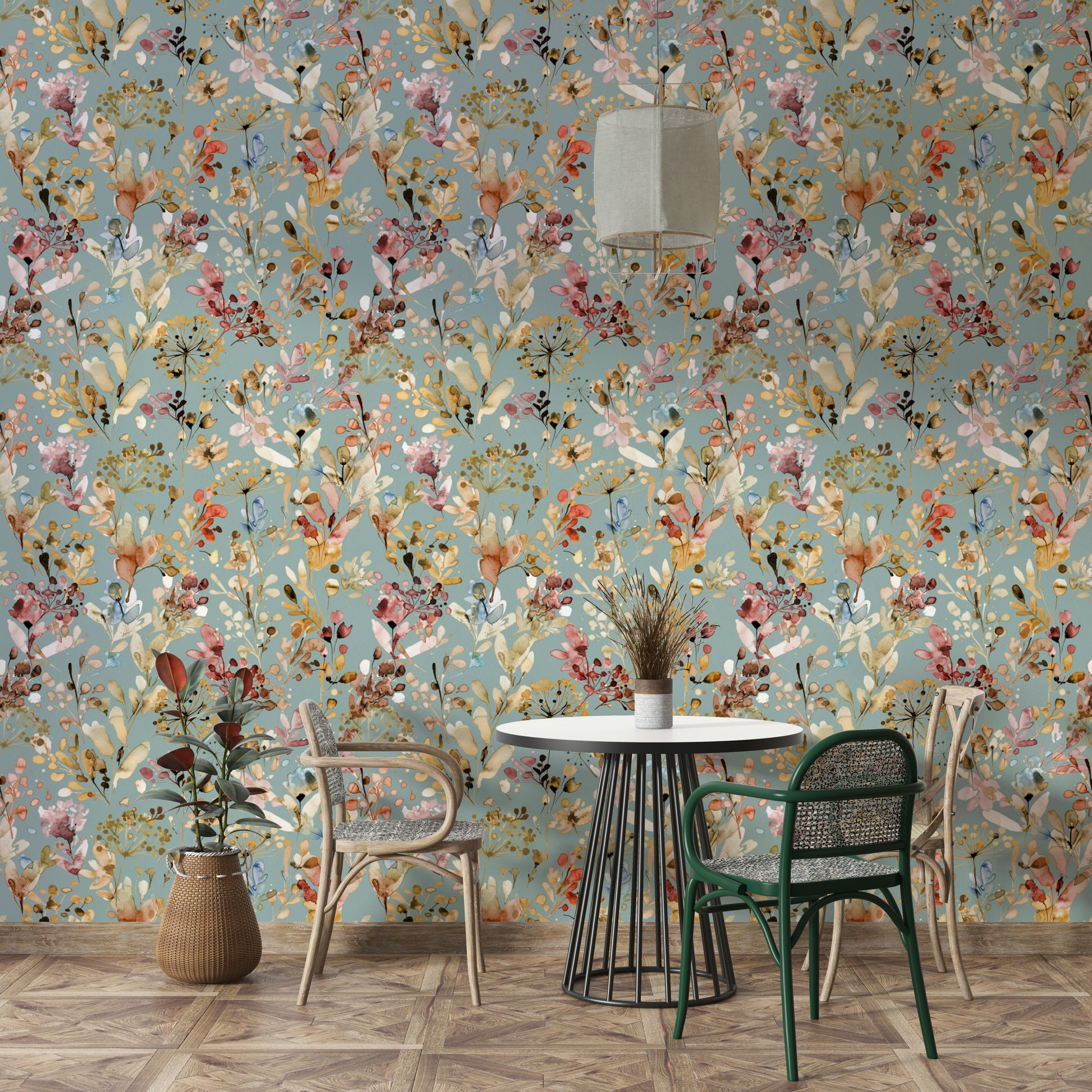 Dark teal botanical wallpaper in a home office with brass lamps and leather chairs.