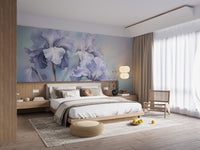 Wild Purple Iris wallpaper mural of soft purple irises behind a white wood platform bed and rattan chair