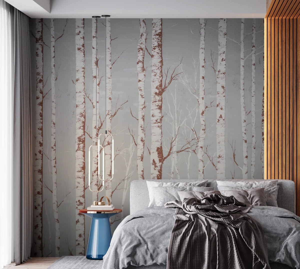 Winter Birch Beauty wallpaper mural of white birch trunks on grey behind a grey bed with a knit throw in a bedroom