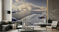 Arctic Dreamscape wallpaper mural of a snowy coast and dark sea behind a grey sectional sofa in a living room