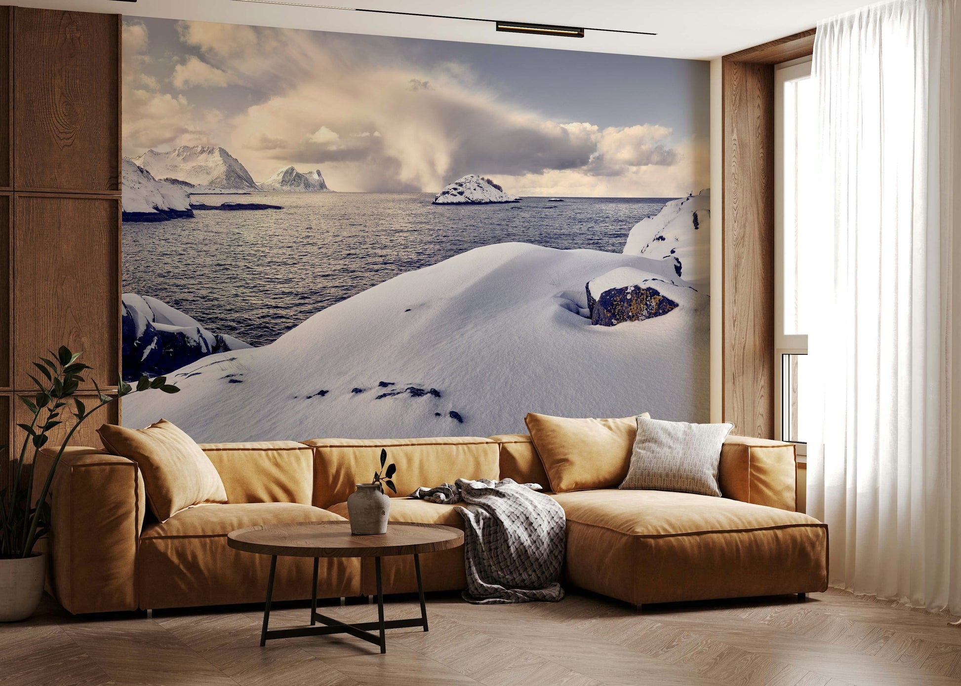 Arctic Dreamscape wallpaper mural of snowy shore and mountains behind a mustard sectional sofa in a living room