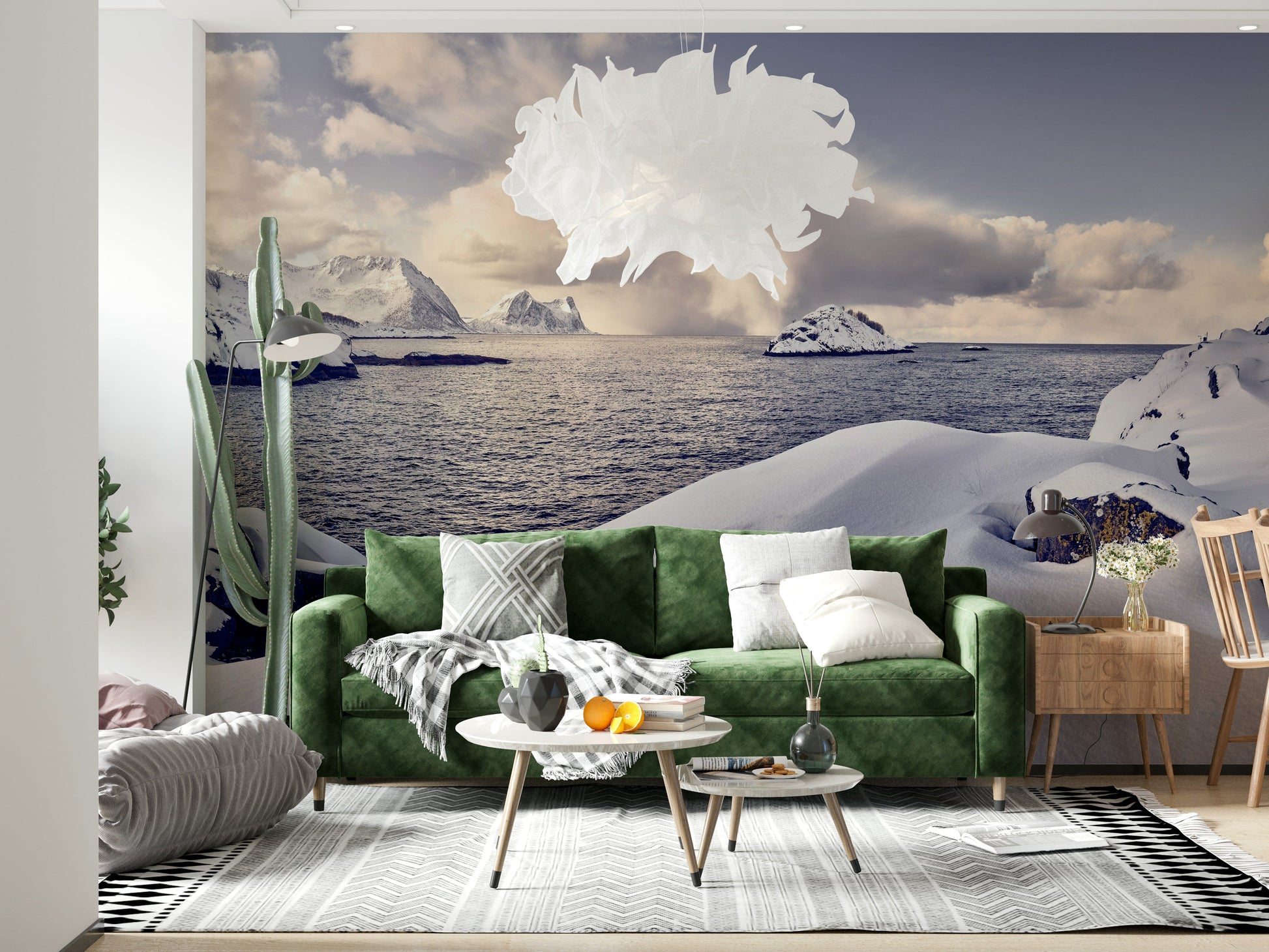 Arctic Dreamscape wallpaper mural of snowy coastline behind a green velvet sofa and white feather pendant