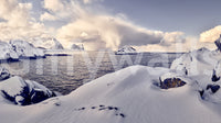 Arctic Dreamscape wallpaper mural shown as a full-wall scene of snowy hills, dark sea and distant mountains