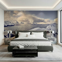 Arctic Dreamscape wallpaper mural of a snowy coast and sea behind a grey bed with chrome lamps in a bedroom