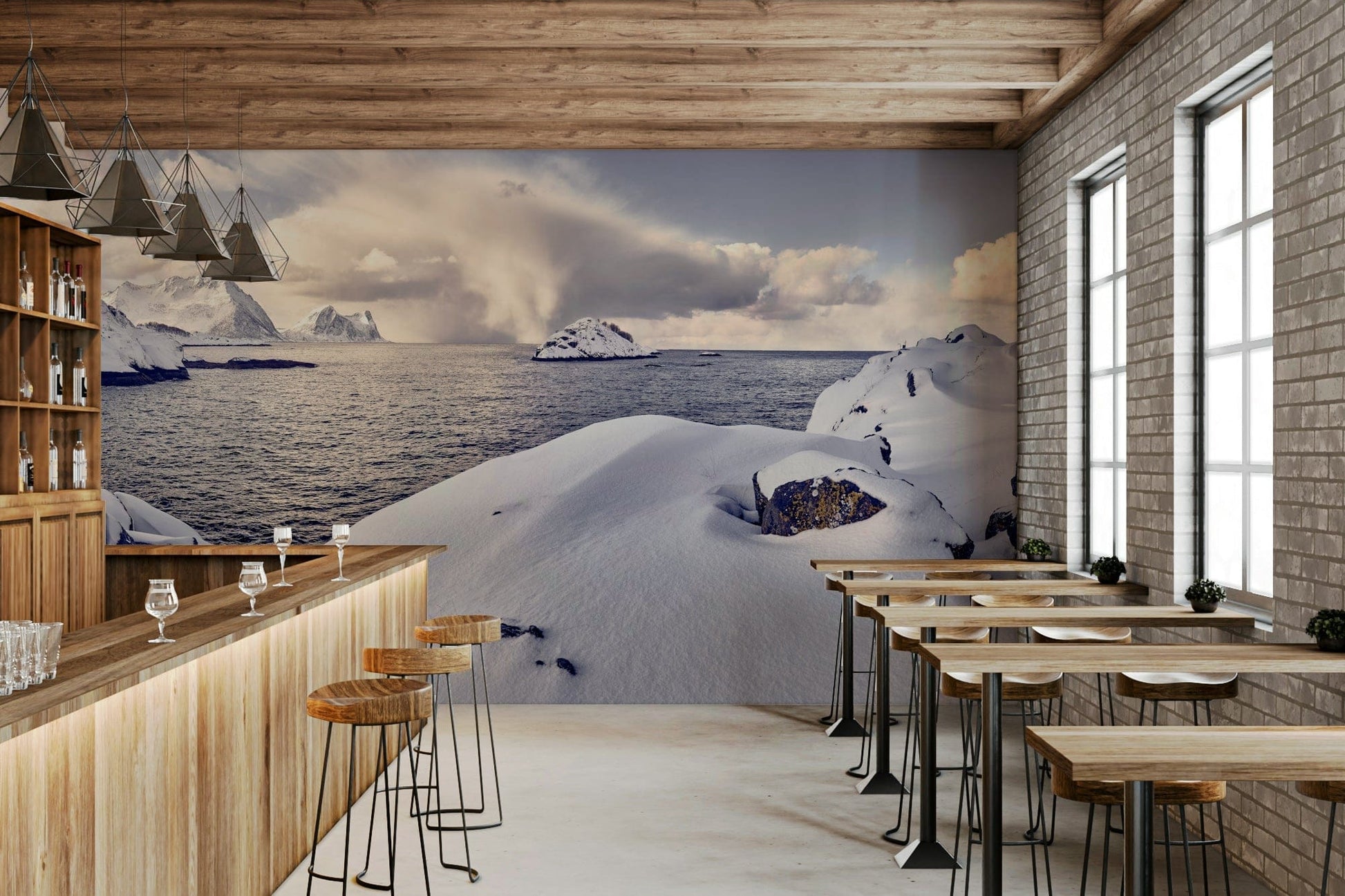 Arctic Dreamscape wallpaper mural of snowy shore and sea behind a wood bar and stools in a brick-walled cafe