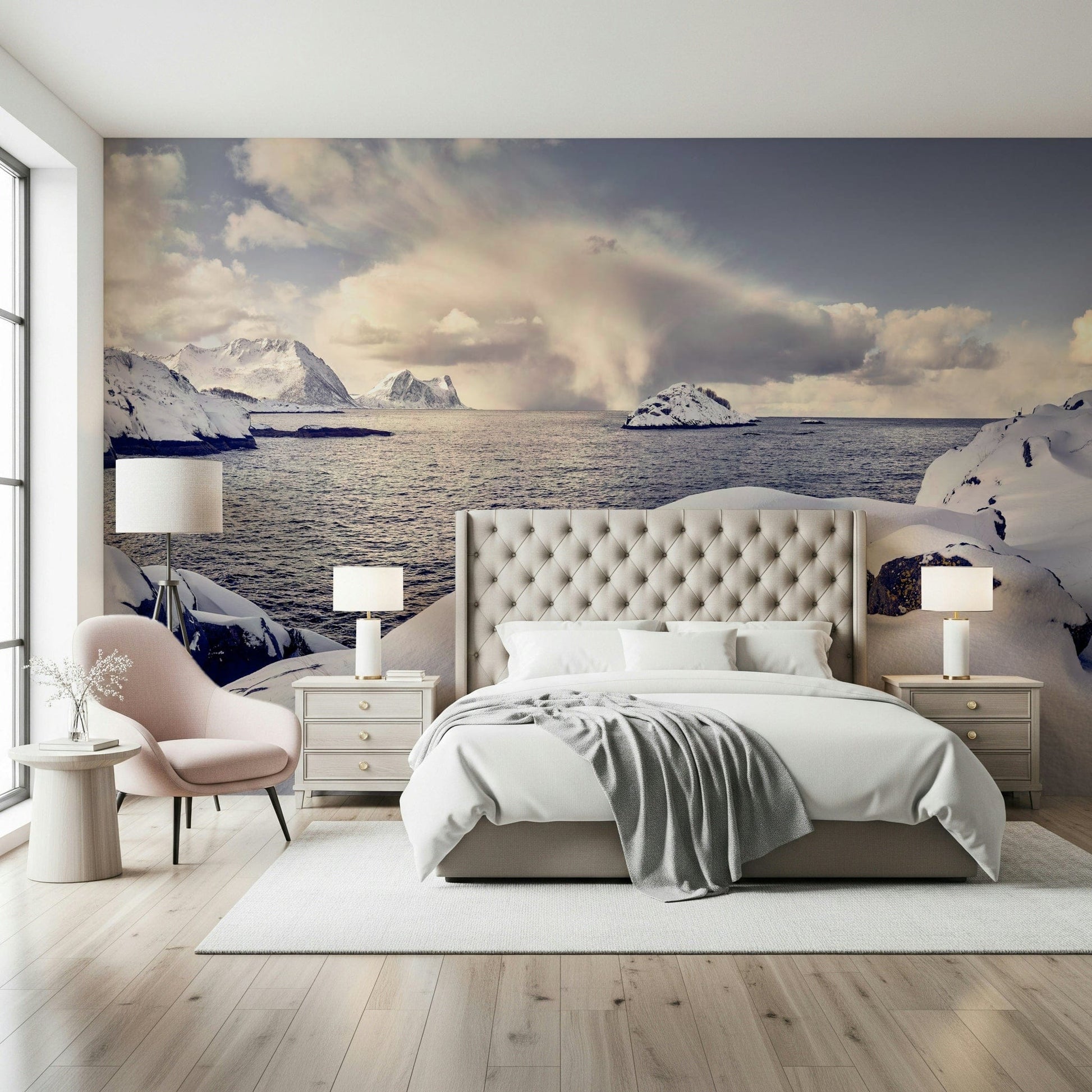 Arctic Dreamscape wallpaper mural of snowy sea cliffs above a cream tufted bed with a pink chair in a bedroom