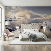 Arctic Dreamscape wallpaper mural of snowy sea cliffs above a cream tufted bed with a pink chair in a bedroom