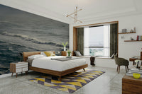 A contemporary living room with a large ocean wave wall mural.

