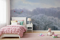 Winter's Whispers wallpaper mural of a snowy winter forest behind a pink ruffled bed and unicorn toy in a girl's room