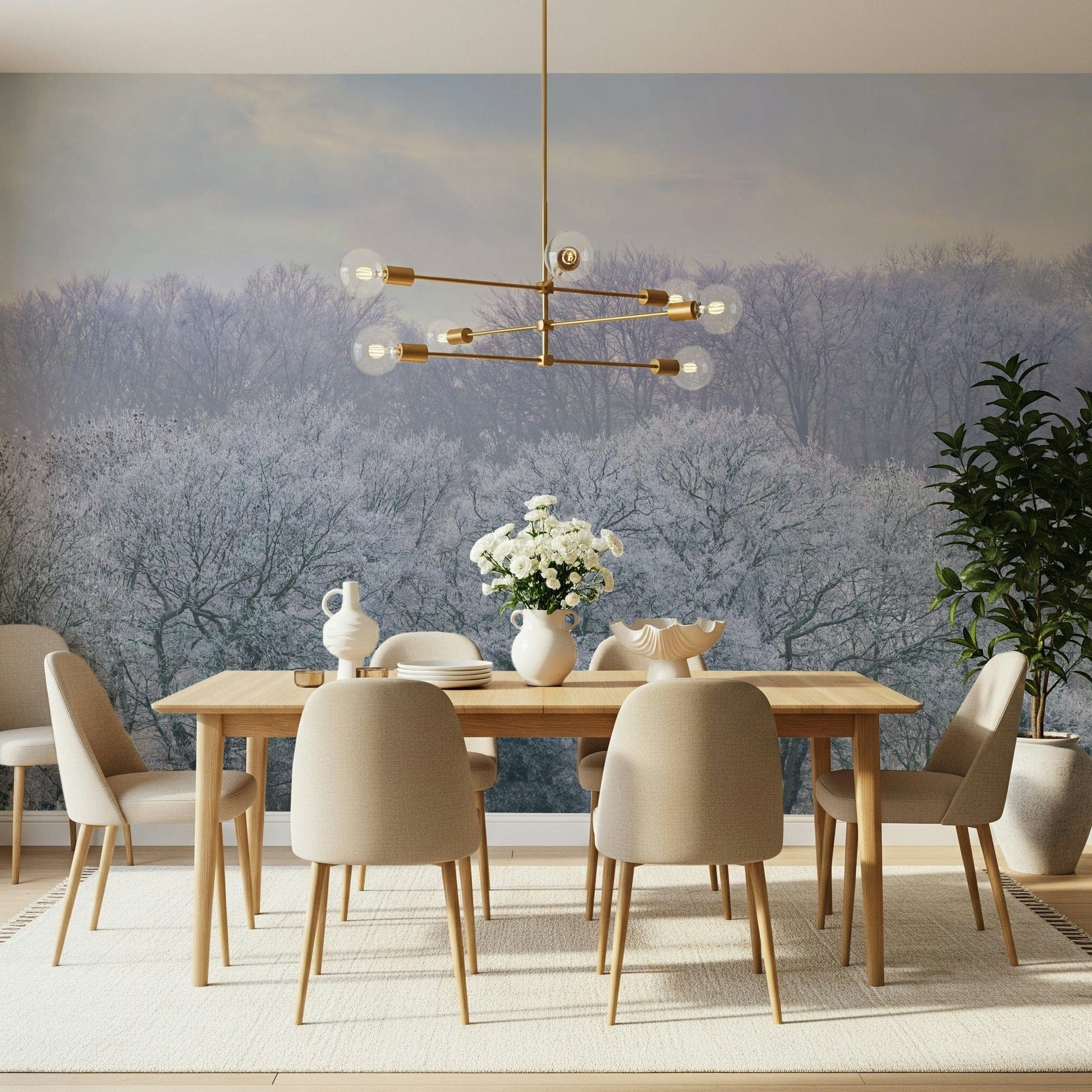 Winter's Whispers wallpaper mural of a misty frosted woodland behind a wood dining table and beige chairs