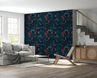 Wonderforest wallpaper in red and teal blooms behind a grey sofa and rattan sideboard in a bright living room