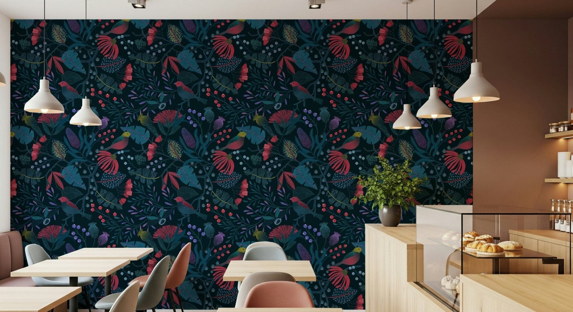 Wonderforest wallpaper with red and teal floral pattern on a cafe wall lined with tables and a pastry counter