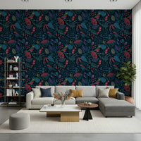 Wonderforest wallpaper with dark navy florals and birds behind a grey sectional sofa and bookshelf in a living room