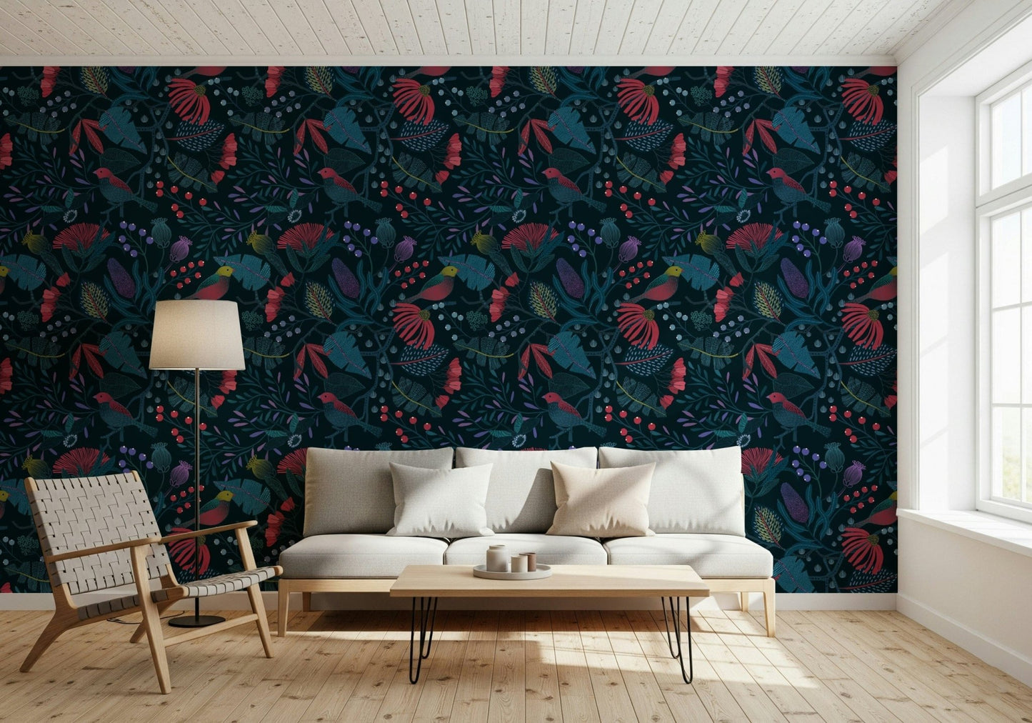 Wonderforest wallpaper of navy blooms and birds behind a white sofa and woven lounge chair in a living room