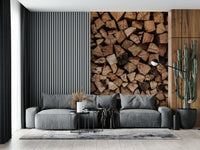 Woodpile Texture wallpaper mural of brown firewood beside a grey sofa and cactus in a living room