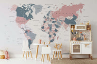 World Map Blush Pink and Indigo wallpaper mural in a kids room with animal-shaped chairs and a toy kitchen