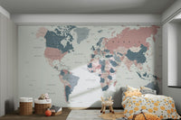 World Map Blush Pink and Indigo wallpaper mural in a kids bedroom with yellow polka-dot bedding and toy baskets
