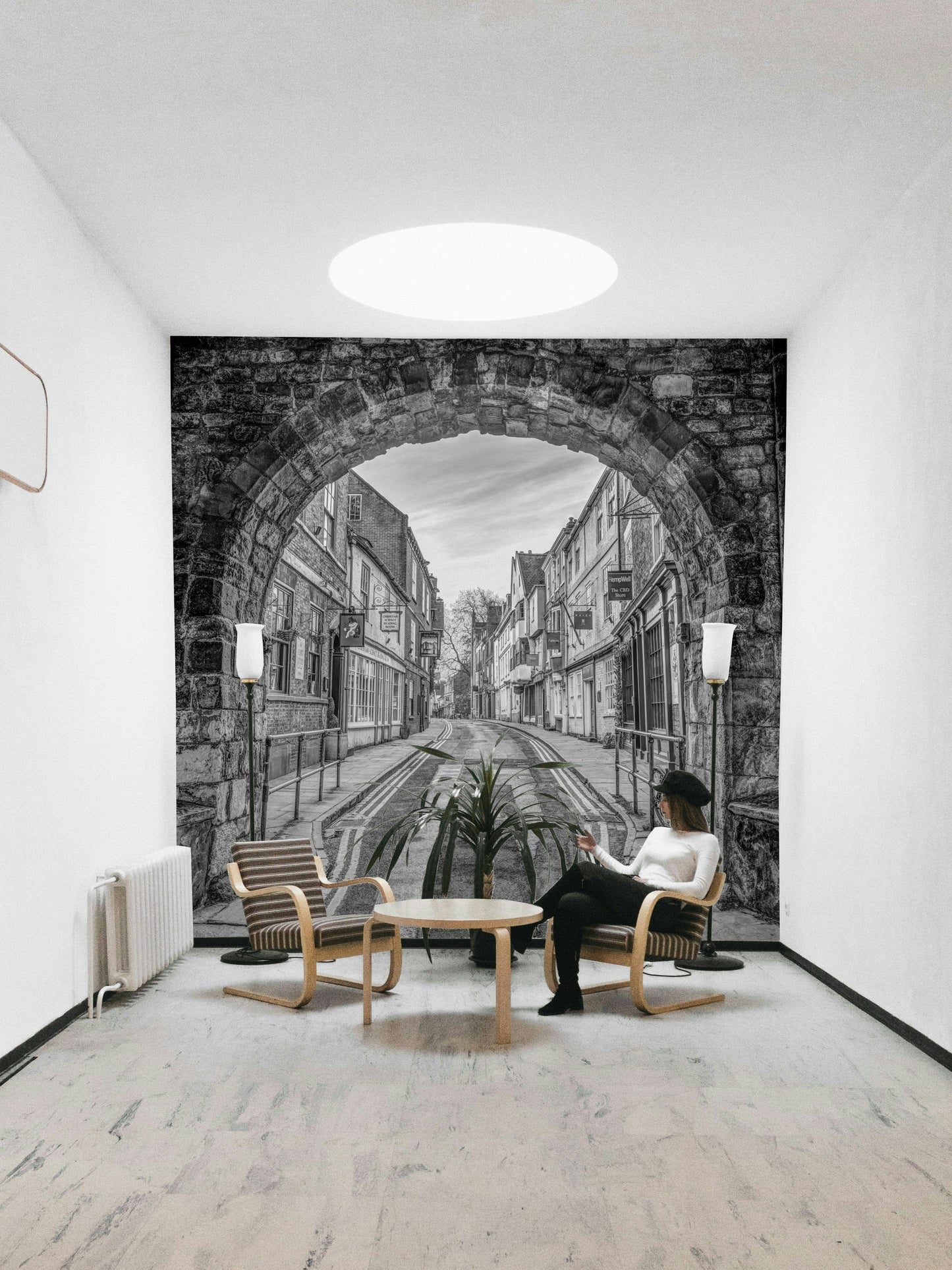 A beautiful, black and white photo of a historic stone archway leading to a street.
