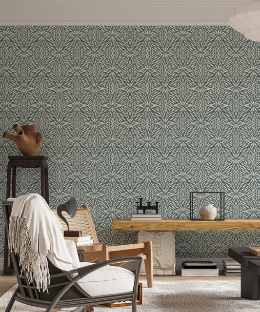 Zenith Leaves wallpaper in sage green botanical pattern behind a cane armchair and wood console in a living room